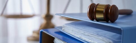 Das Heizungsgesetz ist verabschiedet. Ein blauer Ordner, darüber ein Richterhammer, daneben eine Waage als Symbol für die Jusitz