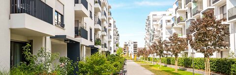 Sektorenkopplung für Immobilien Mehrfamilienwohnblöcke mit grüner Bepflanzung dazwischen