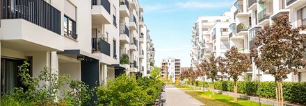 Sektorenkopplung für Immobilien Mehrfamilienwohnblöcke mit grüner Bepflanzung dazwischen