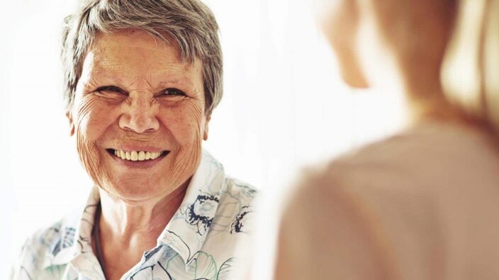 Eine ältere Frau freut sich über EWE business Wärme in einer Pflegeeinrichtung