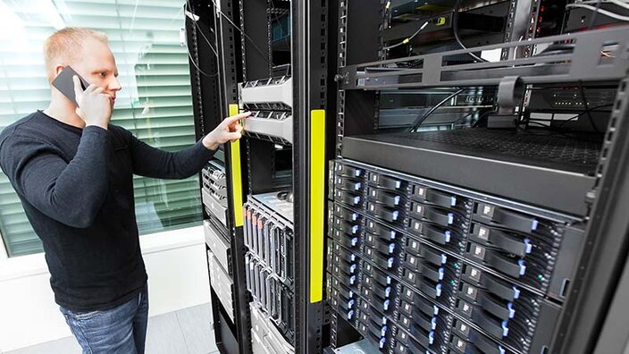 Ein Serverschrank, der von einer IT-Fachkraft geprüft wird