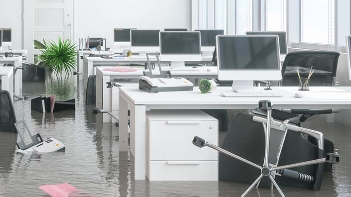Bürotische mit Computern in einem überfluteten Büro