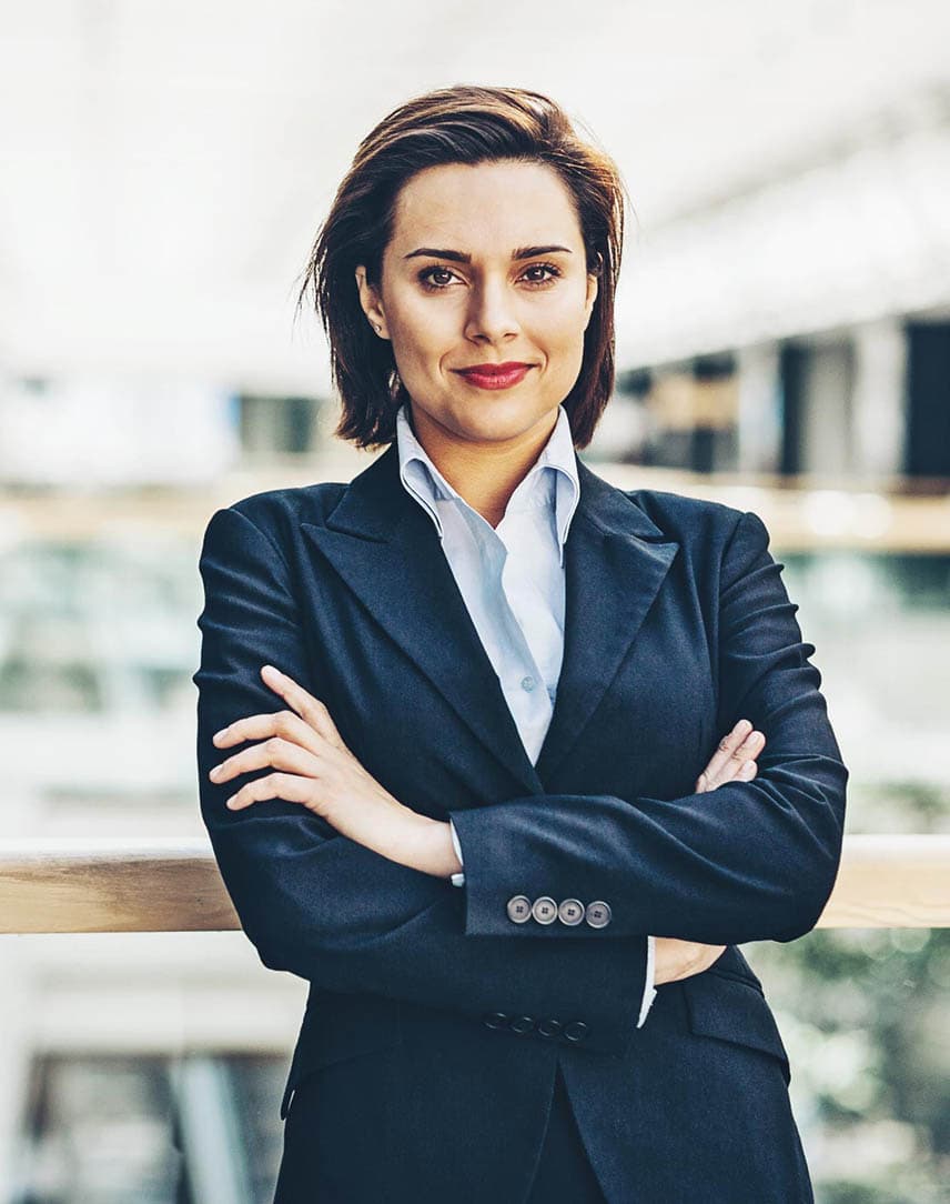 Eine Frau in einem Unternehmensgebäude, die die Arme verschränkt