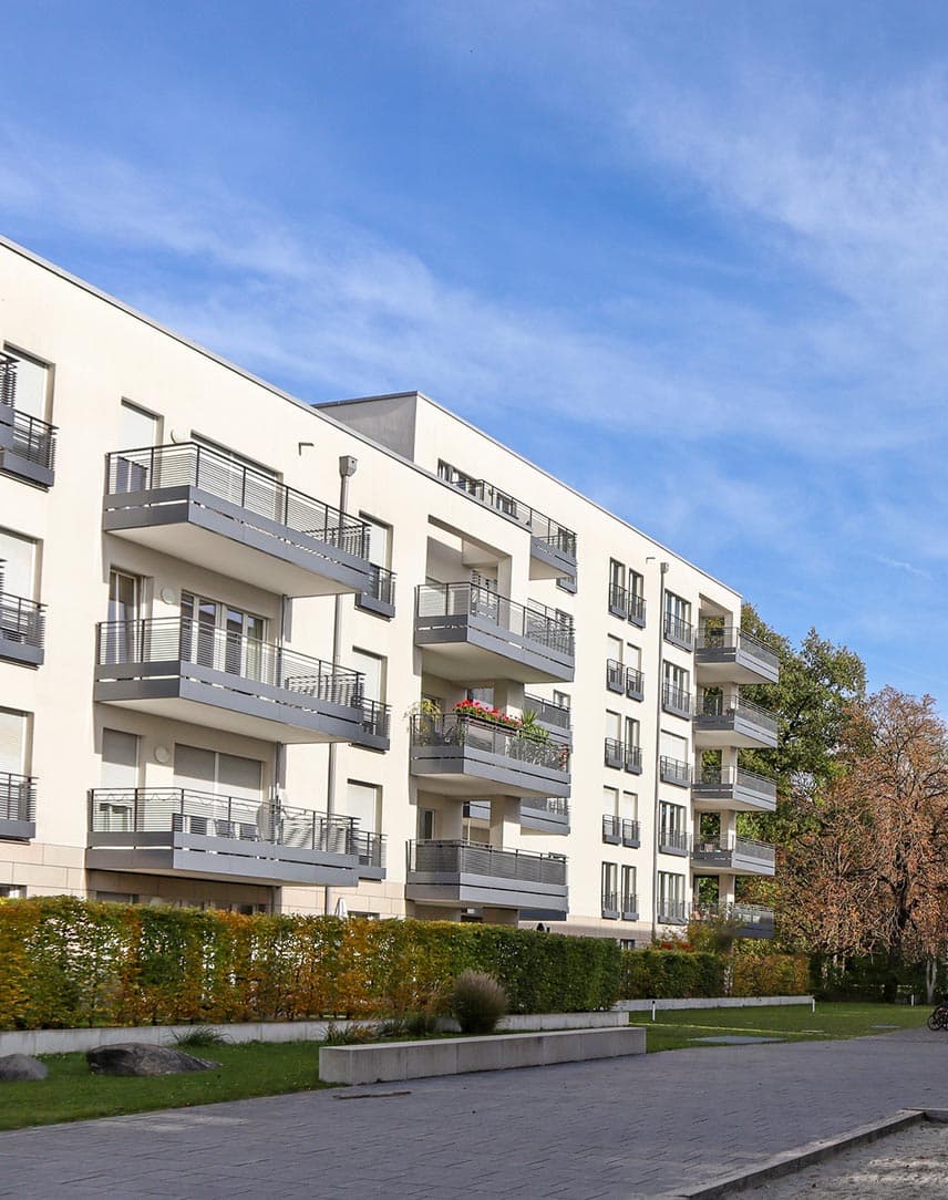 Helle, moderne Wohnblöcke mit bepflanzten Freiflächen