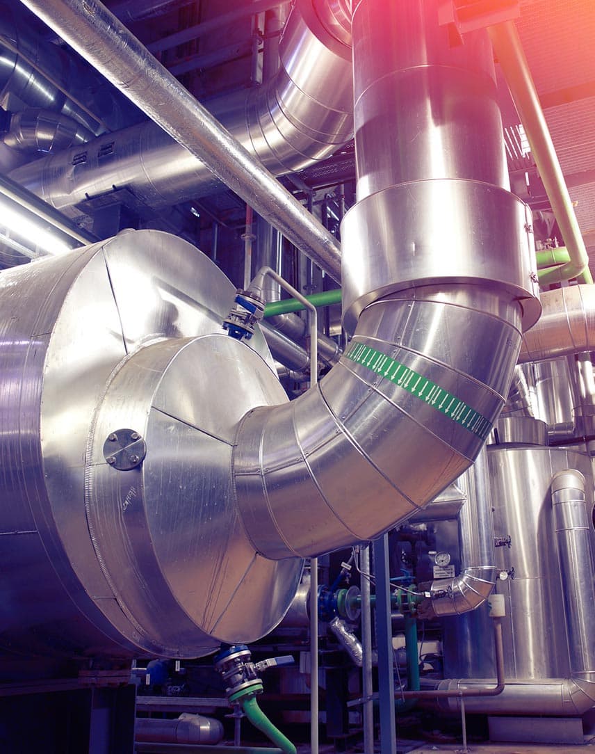 Silberne Kessel und Rohre in einer Fabrikhalle