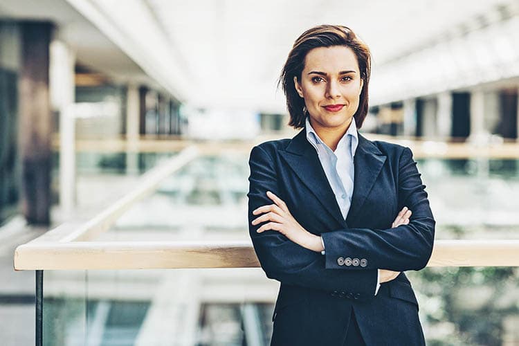 Eine Frau in einem Unternehmensgebäude, die die Arme verschränkt