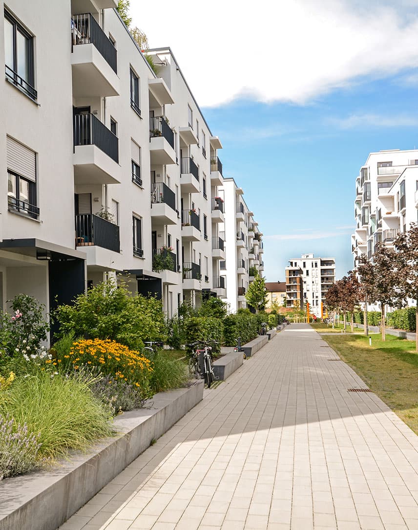 Mehrfamilienwohnblöcke mit grüner Bepflanzung dazwischen
