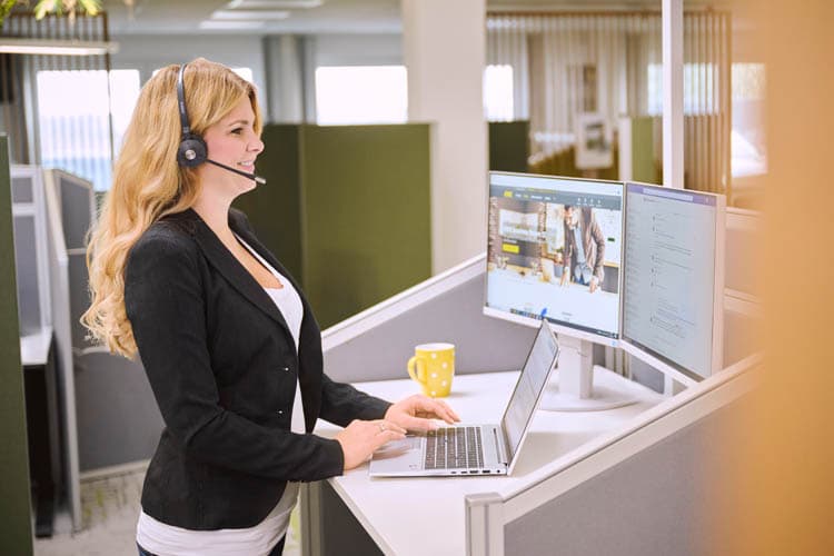 Eine Service-Mitarbeiterin, die mit Headset am Computer für den EWE Service arbeitet