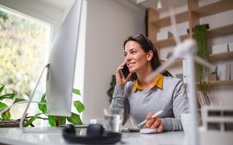 Grüne Produkte mit EWE business Eine Frau an einem Schreibtisch in einem Büro, die telefoniert