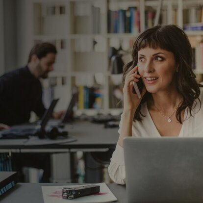 Phishing Frau telefoniert am Smartphone im Büro