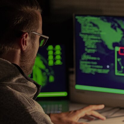 Phishing Mann betrachtet Daten am Computer-Bildschirm