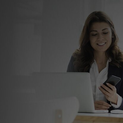 EWE Endpoint Protection Frau mit Handy in der Hand vor dem Laptop