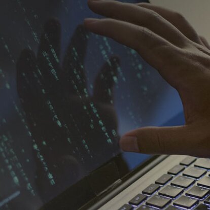 EWE DDoS-Schutz Stilisierte Hand eines Hackers greift zu laptop-Bildschirm