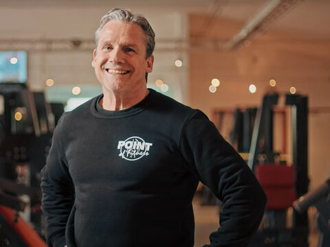 EWE business Referenz Point of Fitness Video Titelbild: Mann lächelnd in Fitnessstudio