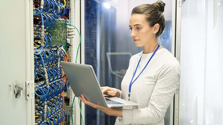 Carrier-Dienste von EWE Eine IT-Expertin mit Laptop vor einem Server