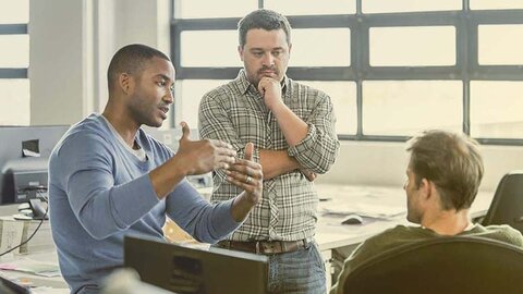 IT-Planung Drei Männer diskutieren in einem Büro etwas.