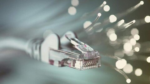 Übertragung der Glasfaser Ein Datenkabel, dahinter Lichtpunkte von Glasfaseradern