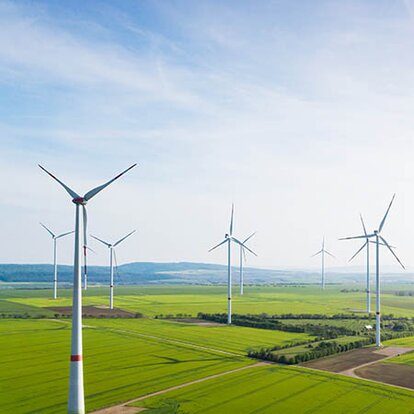 EWE Naturwatt Strom Windräder, dazwischen grüne Felder