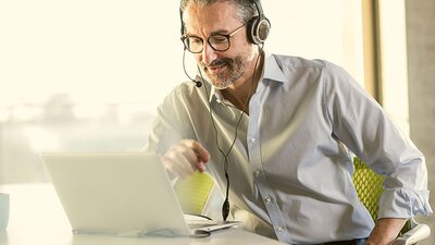 Glasfaser von EWE Mann im Hemd mit Headset am Laptop