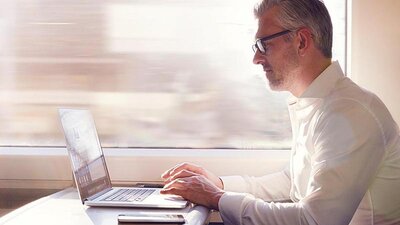 Cloud PBX von EWE Mann im Zug am Laptop