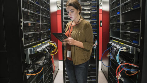 Cloud PBX von EWE Frau schaut auf ein Tablet im Serverraum