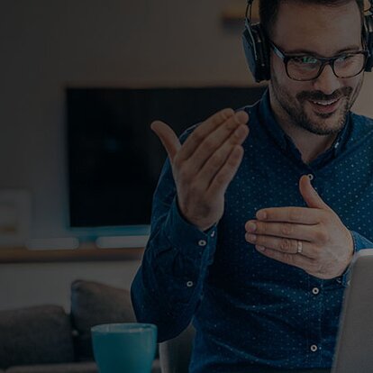 EWE Security Awareness Mann mit Headset erklärt etwas vor dem Laptop