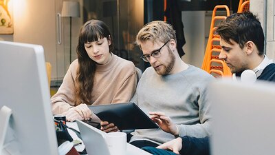 EWE Managed Firewall Drei Personen schauen auf ein Laptop im Büro