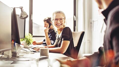 fm Systemmöbel Frau mit Brille lächelnd in Büro