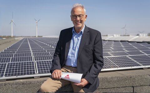 EWE business Referenz Hase Mann mit Brille vor PV-Anlage