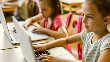 Schule digital Mehrere Kinder arbeiten an Computern.