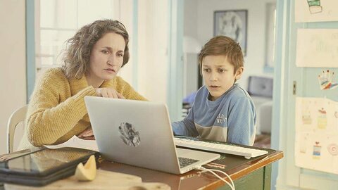 Schule digital Eine Frau zeigt einem Schüler etwas auf einem Computer.