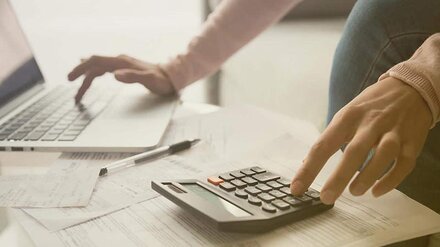 Schule digital Eine Person bedient Taschenrechner und Computer.