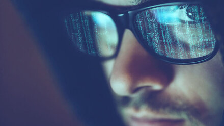IT-Security von EWE Stilisierter Hacker blickt in die Kamera